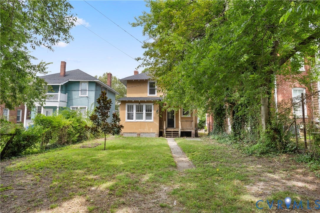 1304 Bainbridge Street, Manchester, Richmond, VA 23224 Front exterior featuring a covered porch with wood railing, multiple windows, and a concrete pathway