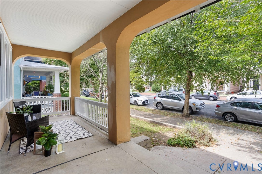1304 Bainbridge Street, Manchester, Richmond, VA 23224 Covered porch with arched entryways, white railing, and concrete flooring