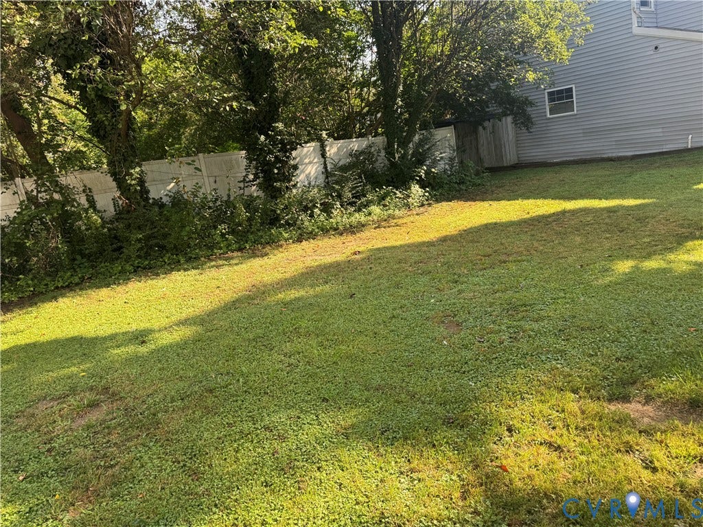 1520 1/3 National Street, Fulton, Richmond, VA 23231 Expansive green lawn with mature trees and a privacy fence