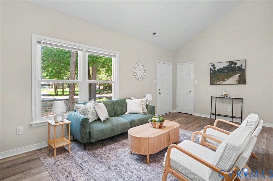 Vaulted ceiling, wood-finish flooring, light-toned wall paint, white trim, and white paneled doors