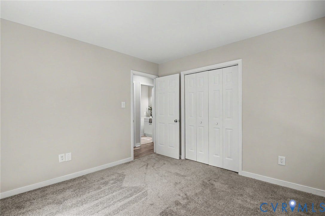 Neutral wall paint, carpet flooring, bi-fold closet doors, and interior door with hardware
