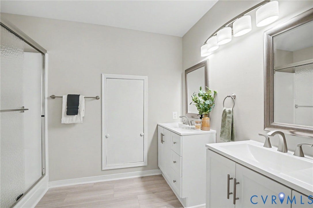Dual vanity with white cabinetry, brushed nickel hardware, and single-basin sinks