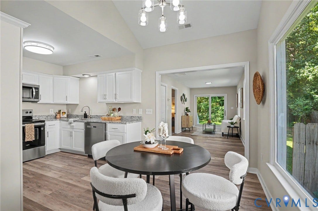 Well-appointed kitchen featuring white cabinetry, granite countertops, and stainless steel appliances