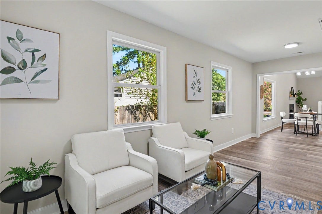 Wood-finish flooring throughout, white trim molding, recessed lighting, and an open entryway to an additional room