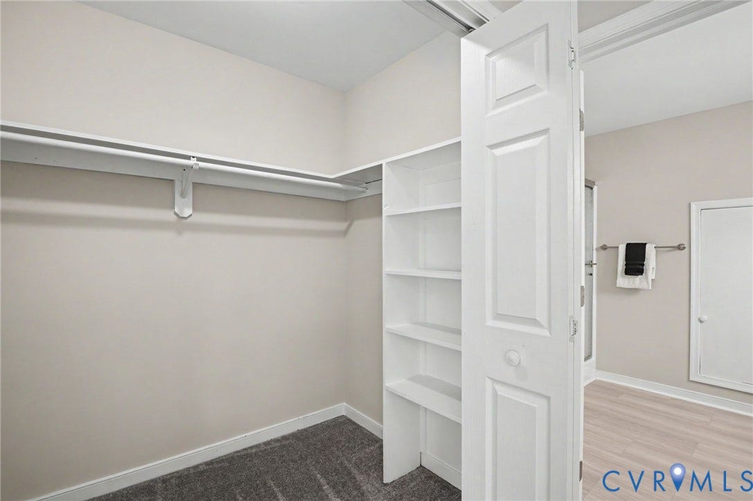 Built-in shelving, carpet flooring, and a clothing rod