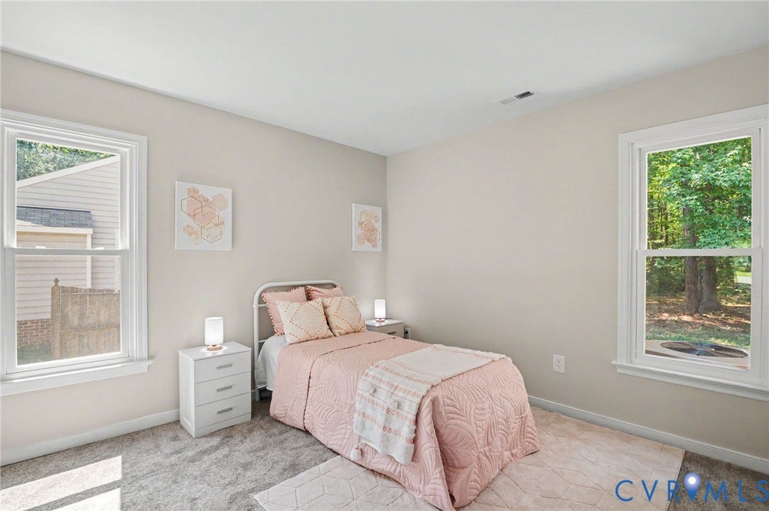 Neutral wall paint, two large windows, and gray carpet