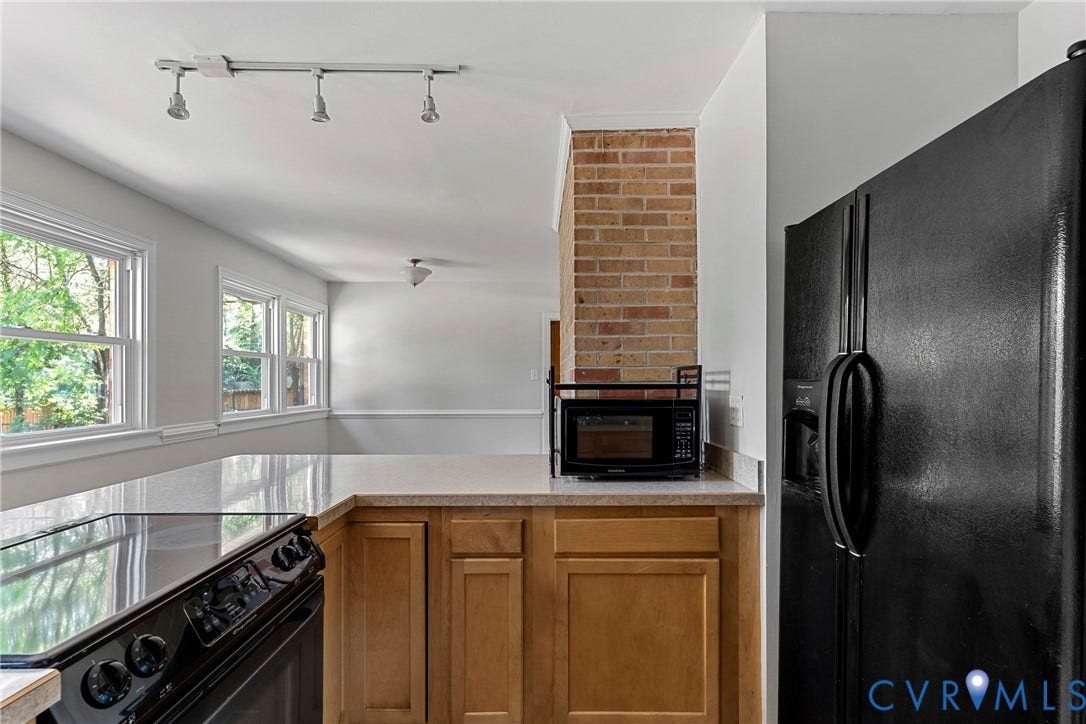 5968 Forest Hill Avenue, Westlake Hills, Richmond, VA 23225 Kitchen featuring a black electric range, black refrigerator, wood cabinetry, and a light-toned countertop