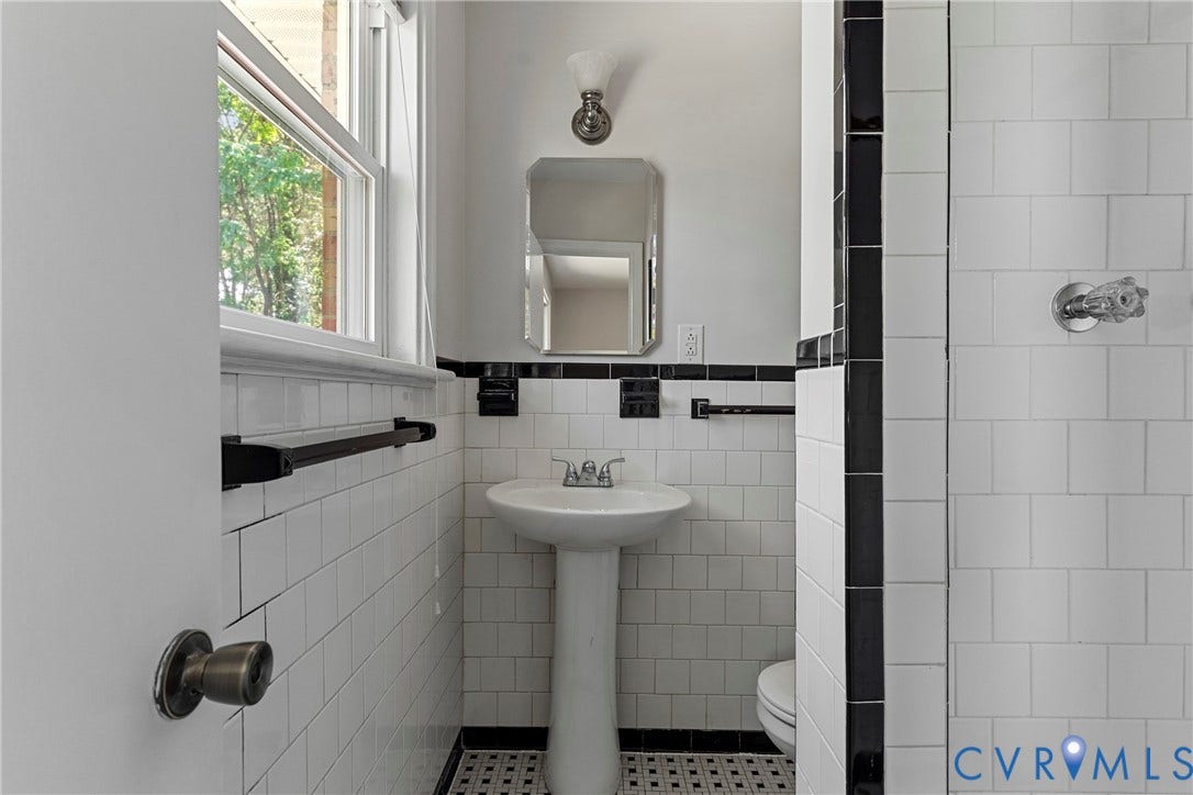 5968 Forest Hill Avenue, Westlake Hills, Richmond, VA 23225 Pedestal sink with chrome faucet, white subway tile, black accent tile, and a wall-mounted mirror