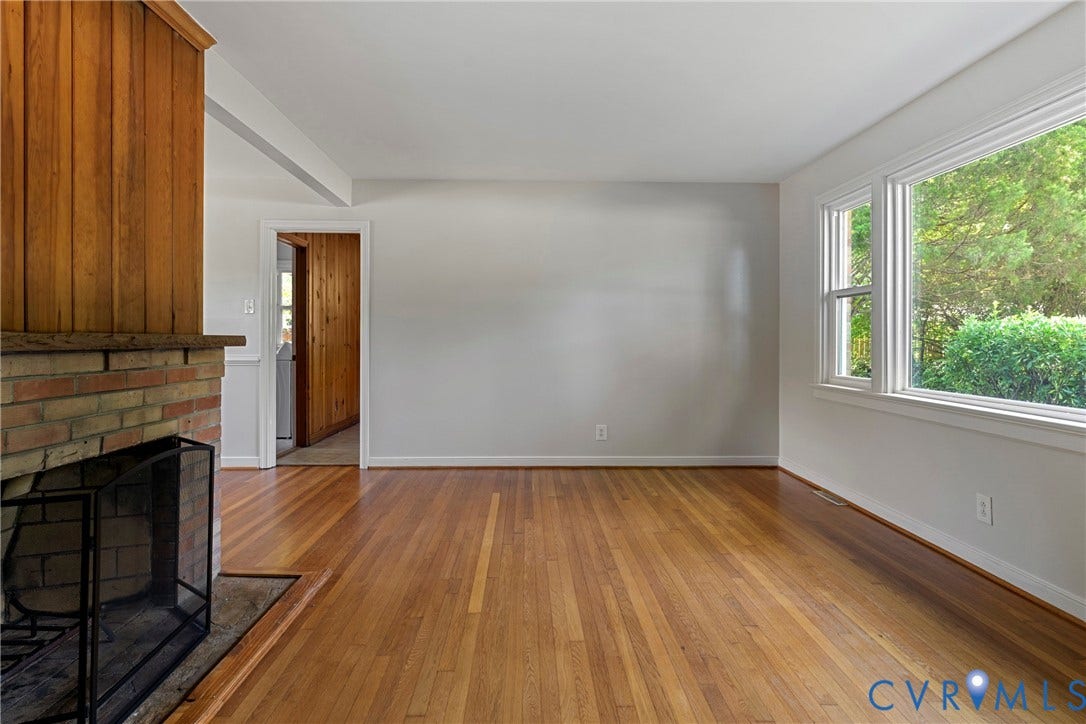5968 Forest Hill Avenue, Westlake Hills, Richmond, VA 23225 Brick fireplace with a wood panel surround, wood-finish flooring, and bright windows
