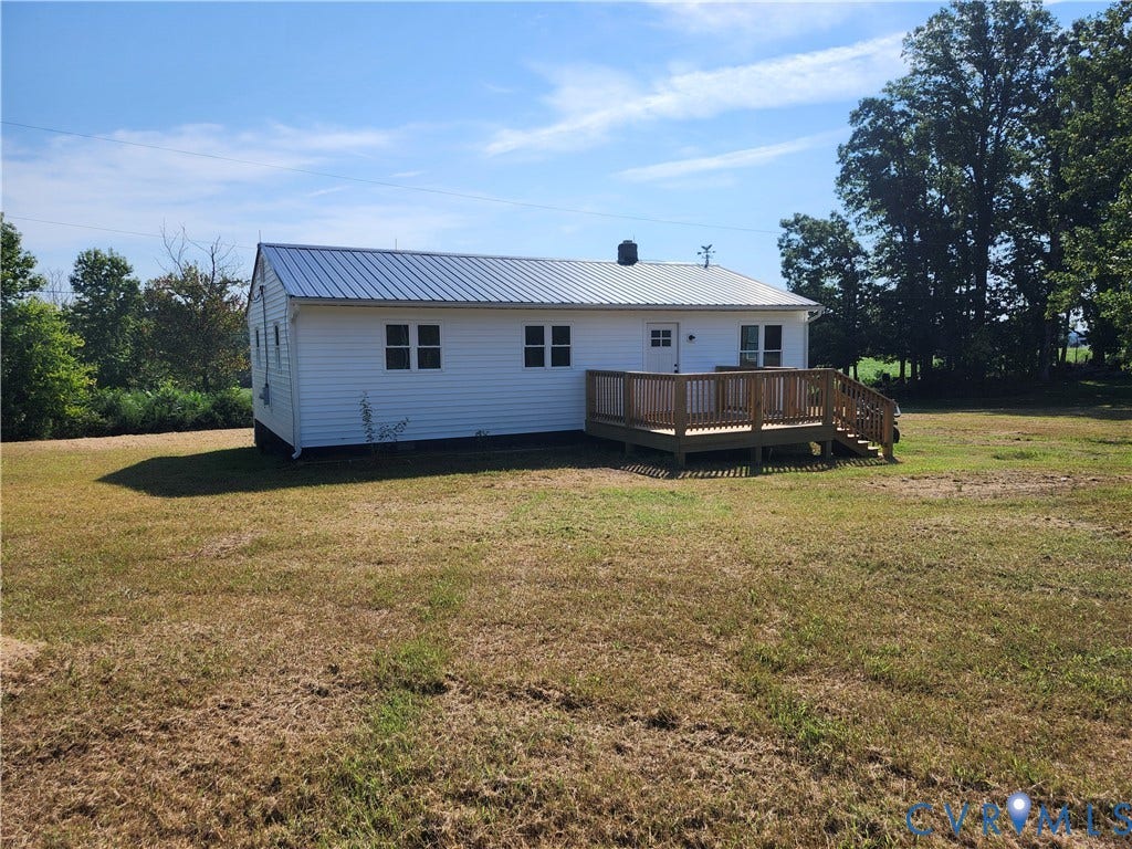 303 Putney Road, Cumberland, VA 23040 White-sided exterior featuring a metal roof, an expansive wooden deck, and multiple windows