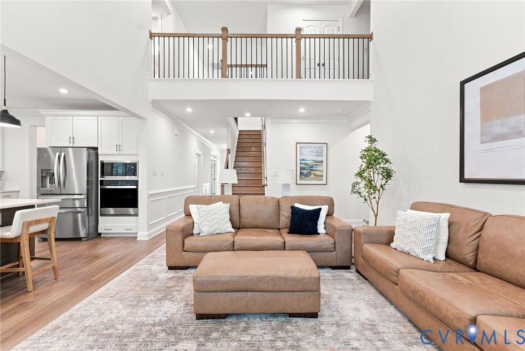 Two-story great room featuring a second-level open railing with wood top, wood-finish flooring, and recessed lighting