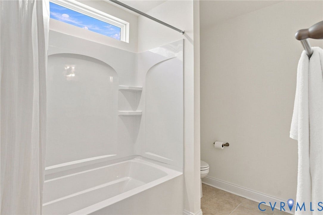 White fiberglass tub/shower combination with integrated shelving