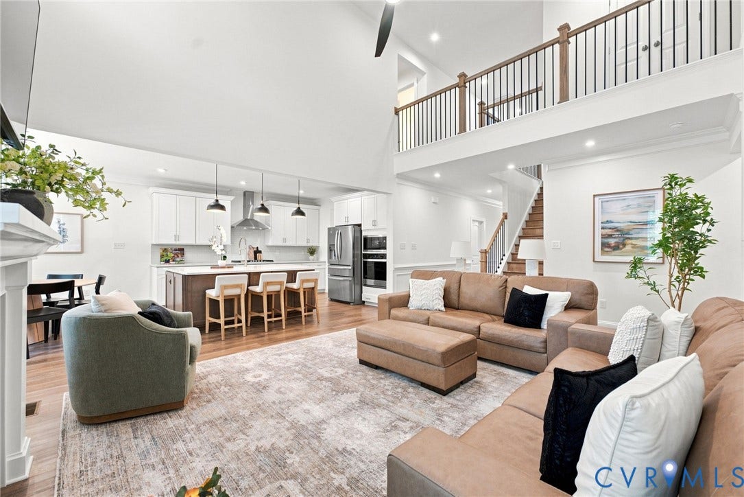 Vaulted ceilings, wood-finish flooring, and a kitchen island with seating are prominent