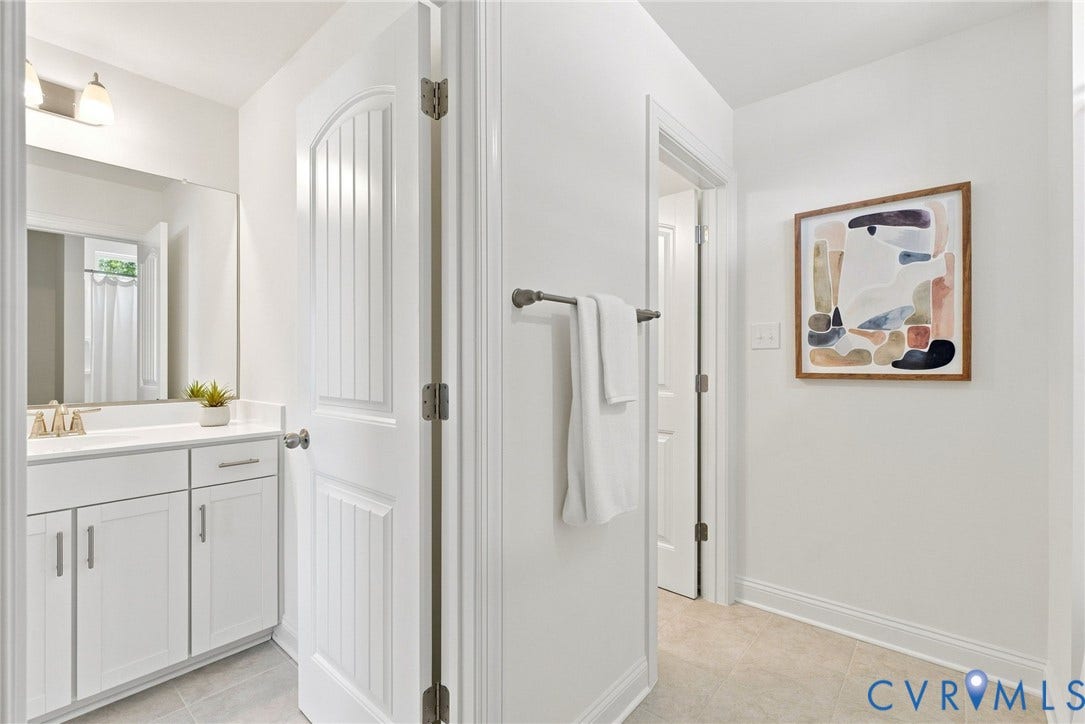 White vanity with shaker-style cabinetry, chrome hardware, recessed lighting, and a full-width mirror