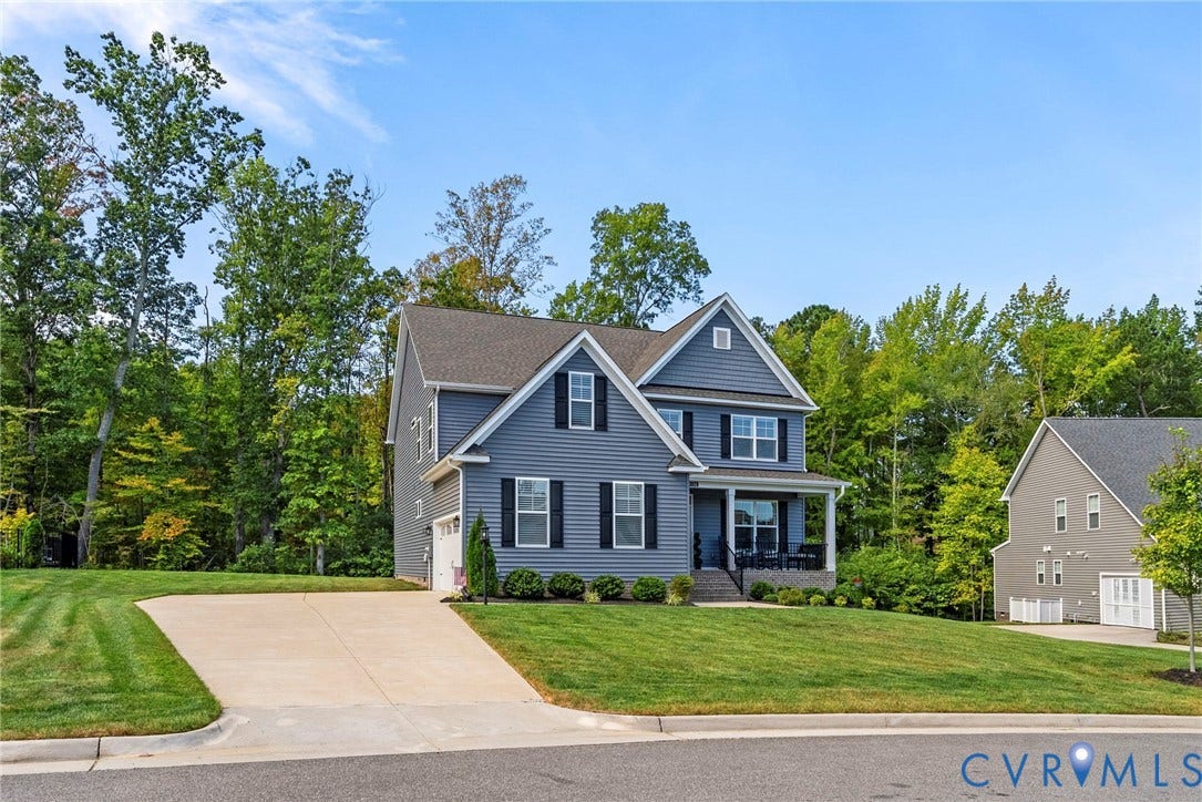 Two-story residence with a gray siding exterior, gabled rooflines, and a covered front porch