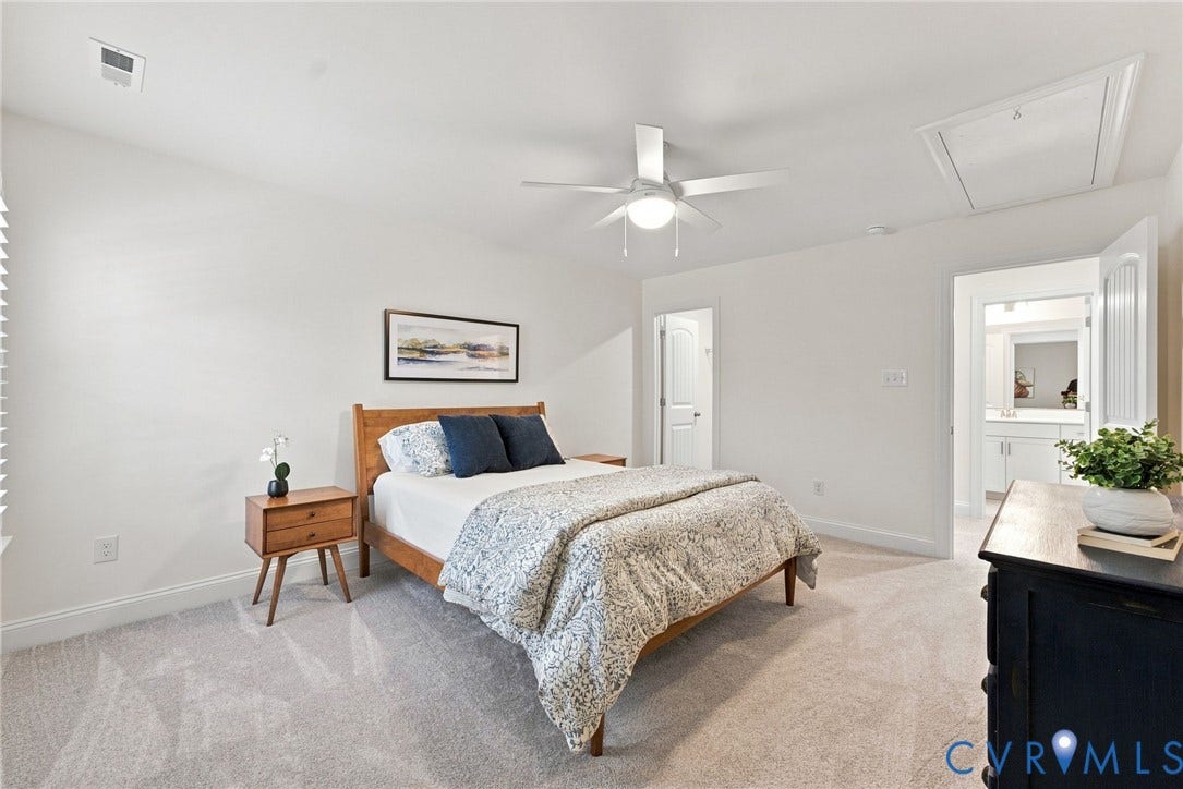 Plush gray carpeting throughout, white painted walls, and a ceiling fan with integrated lighting