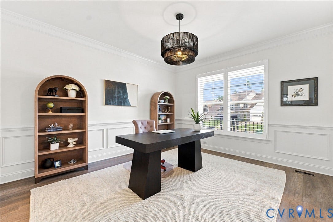 Crown molding and wainscoting details, wood-finish flooring, and a modern ceiling fixture