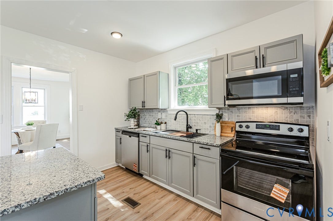 4008 River Road, Chesterfield, VA 23803 Kitchen featuring wood-finish flooring, gray cabinetry, speckled countertops, stainless steel appliances, and a tiled backsplash