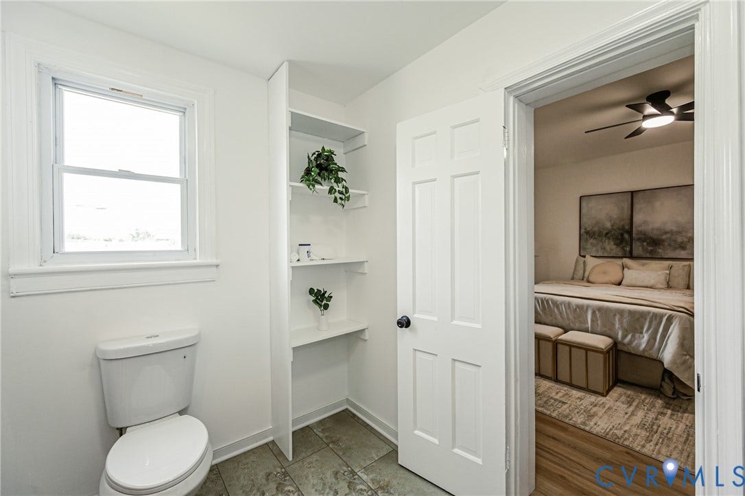 4008 River Road, Chesterfield, VA 23803 White paneled door, built-in shelving, window with white trim, white toilet, and tile flooring