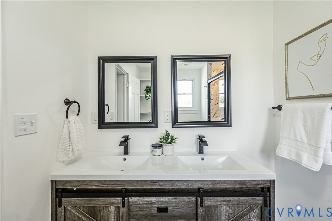 4008 River Road, Chesterfield, VA 23803 Dual rectangular mirrors above a rustic wood-finish vanity with barn door style cabinetry and matte black fixtures