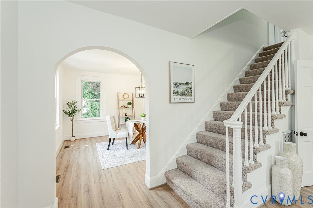 4008 River Road, Chesterfield, VA 23803 Carpeted staircase with white balusters, arched doorway, and wood-finish flooring
