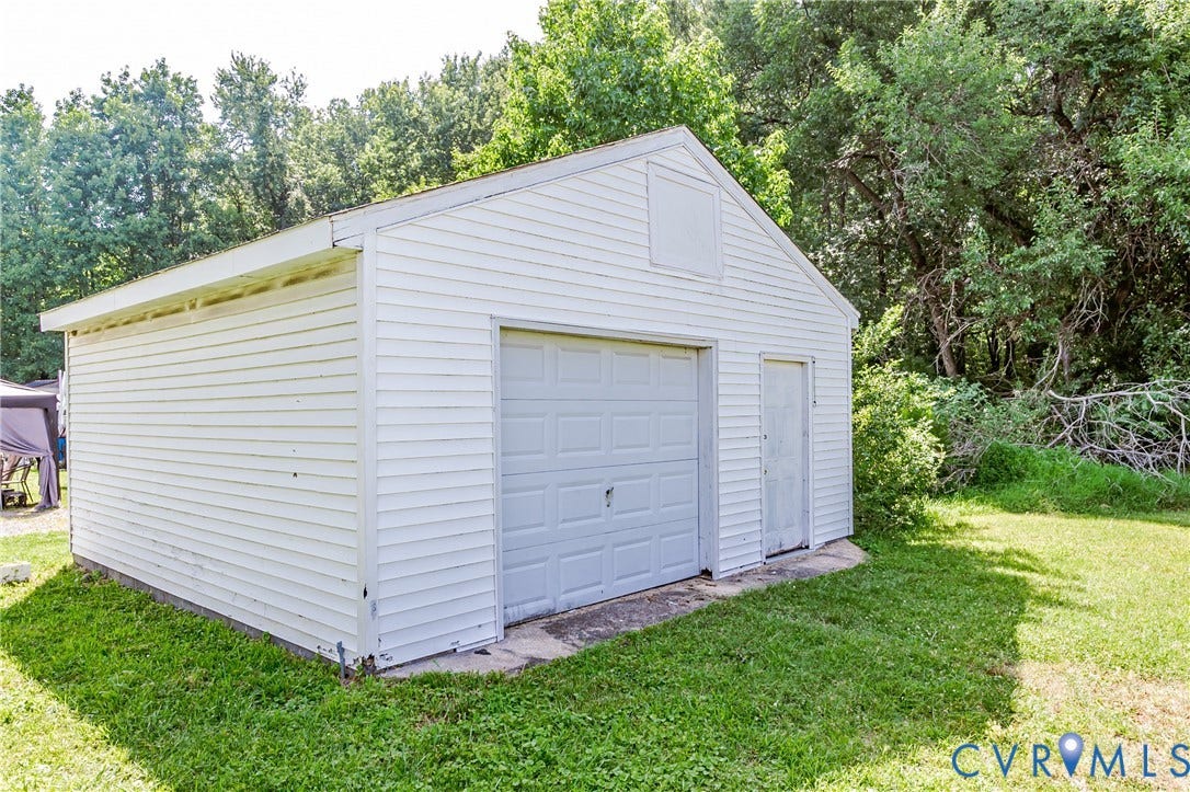 4008 River Road, Chesterfield, VA 23803 Detached garage featuring a roll-up door, side entry door, and horizontal siding