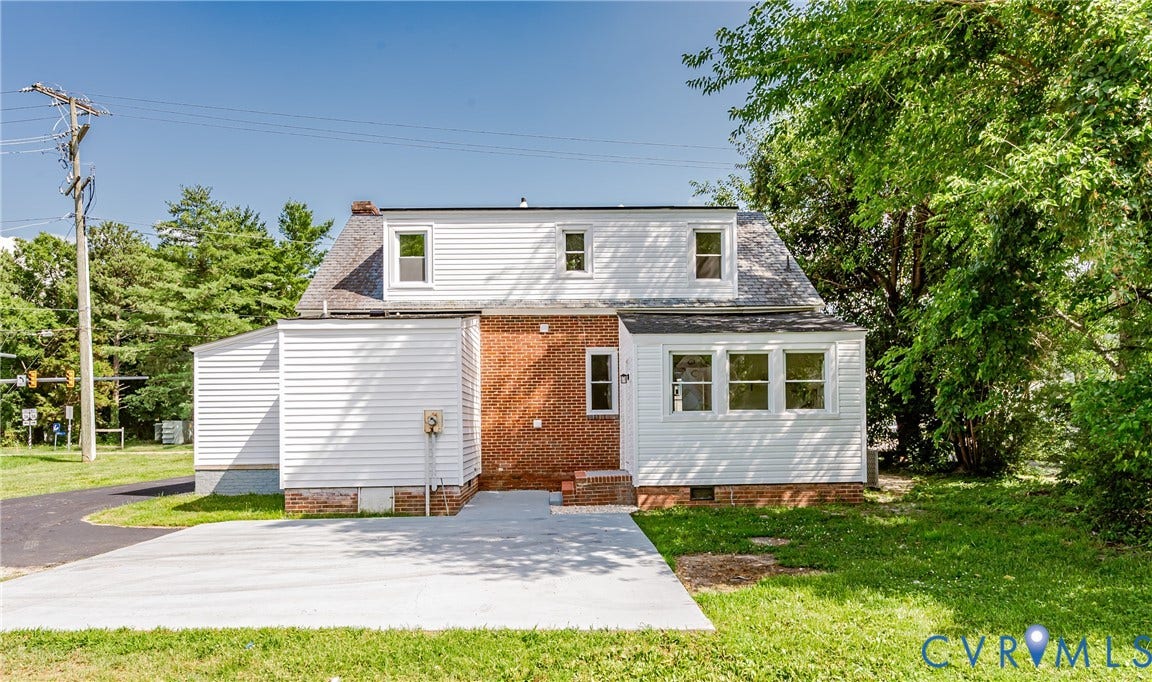 4008 River Road, Chesterfield, VA 23803 White siding exterior with a brick accent, multiple windows, a concrete patio, and a paved driveway