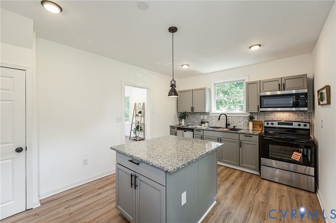 4008 River Road, Chesterfield, VA 23803 Kitchen featuring an island with a light-toned countertop, gray cabinetry, stainless steel appliances, and wood-finish flooring