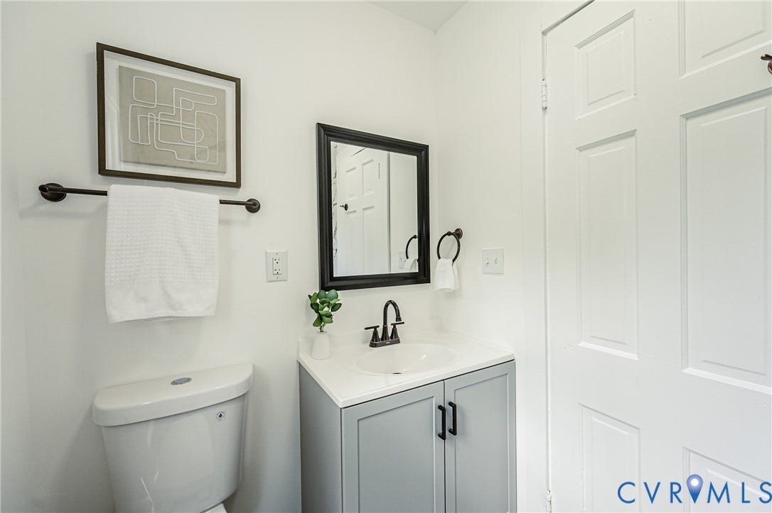 4008 River Road, Chesterfield, VA 23803 White vanity with a single basin sink, matte black faucet, and cabinet storage