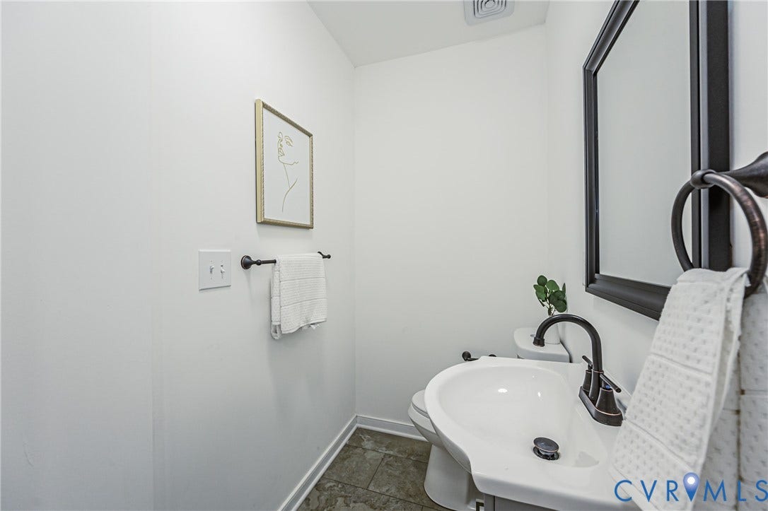 4008 River Road, Chesterfield, VA 23803 Pedestal sink with dark bronze fixtures, dark framed mirror, and tiled flooring