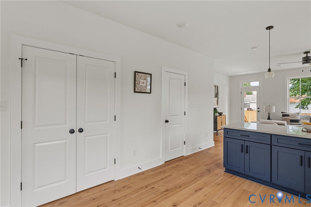 2004 Newbourne Street, Richmond, VA 23223 Wood-finish flooring, white paneled doors, blue shaker-style cabinetry with matte black hardware, white countertop, and recessed lighting