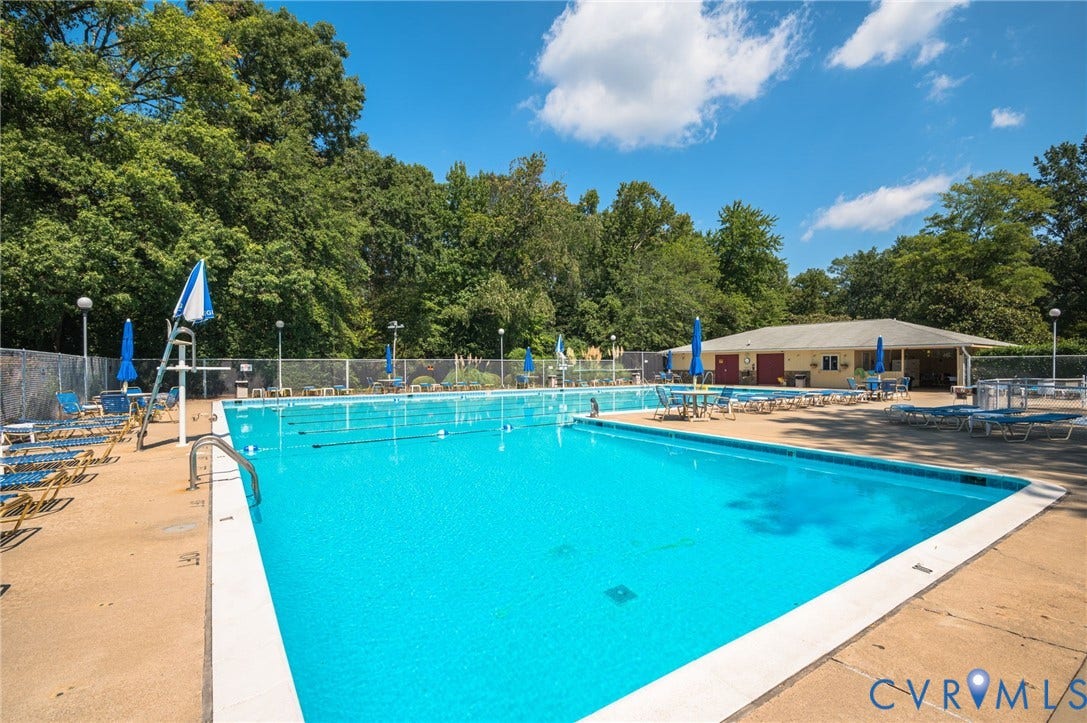 1555 Skirmish Run Drive, #1555, Henrico, VA 23228 Outdoor swimming pool with concrete decking, surrounding mature trees, and a separate poolside building