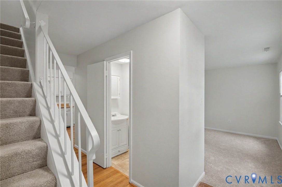 1555 Skirmish Run Drive, #1555, Henrico, VA 23228 Carpeted staircase with white railings, hardwood flooring, and a powder room with pedestal sink