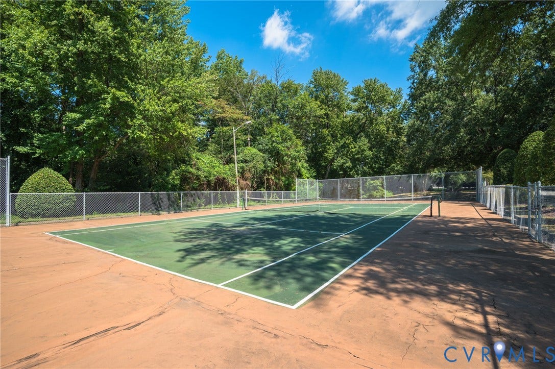 1555 Skirmish Run Drive, #1555, Henrico, VA 23228 Tennis court with a green playing surface, perimeter fencing, and surrounding mature trees