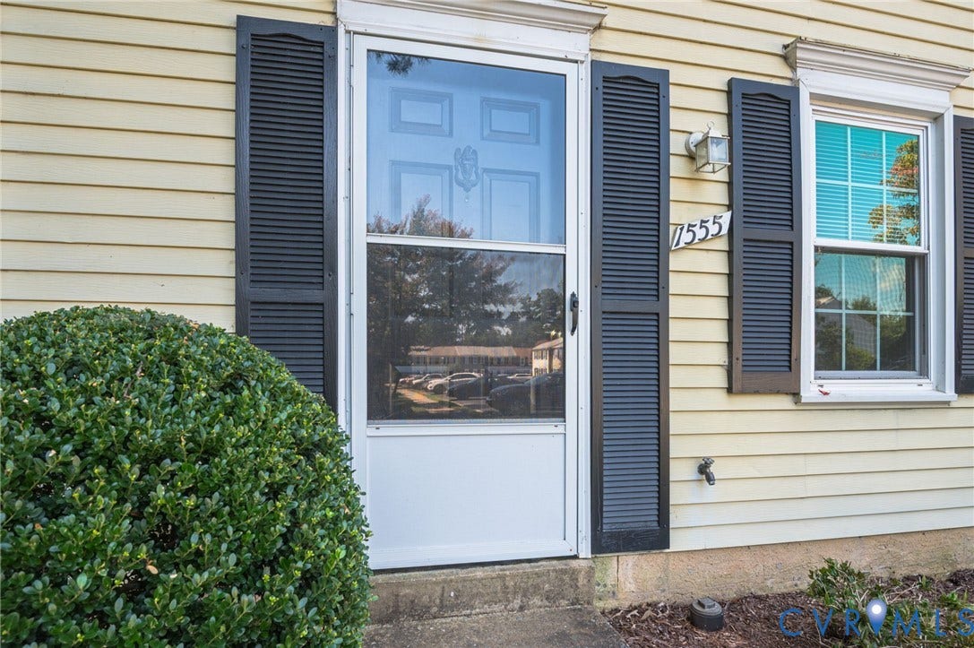 1555 Skirmish Run Drive, #1555, Henrico, VA 23228 Yellow horizontal siding, black louvered shutters, white storm door, exterior light fixture, and house numbers 7555