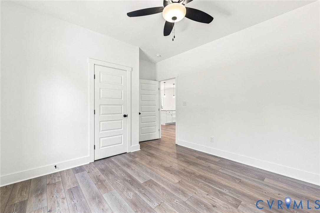 3289 Cumberland Road, Cumberland, VA 23040 Green siding exterior with a dark shingled roof, featuring a wooden deck with railing, white trim windows, and a brick foundation
