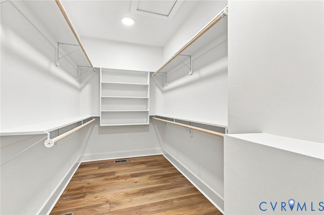 3289 Cumberland Road, Cumberland, VA 23040 Bright room with wood-finish flooring, two large windows, a ceiling fan with integrated lighting, and crisp white walls