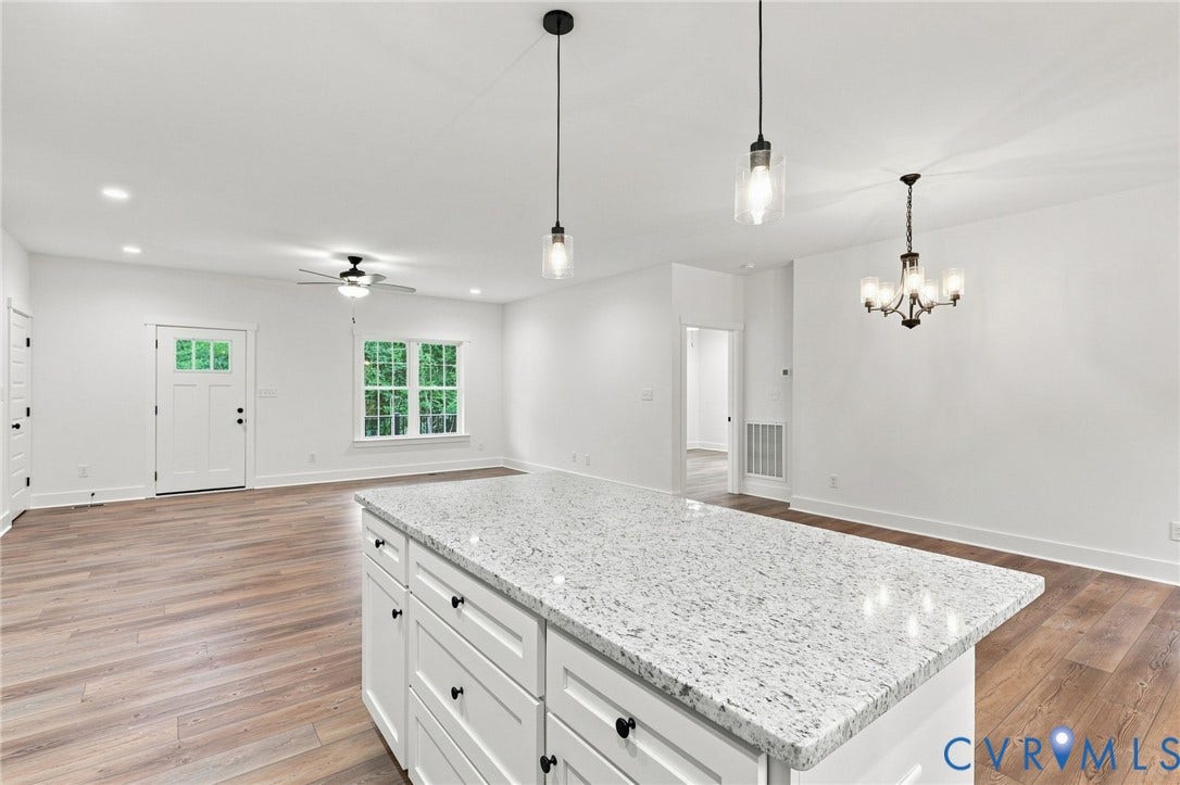 3289 Cumberland Road, Cumberland, VA 23040 Wood-finish flooring, white cabinetry with black hardware, and a window providing natural illumination