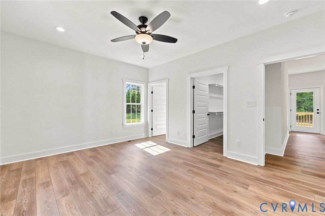 3289 Cumberland Road, Cumberland, VA 23040 Open-concept living area featuring wood-finish flooring, a contemporary ceiling fan, and a kitchen with white cabinetry, stainless steel appliances, and a central island