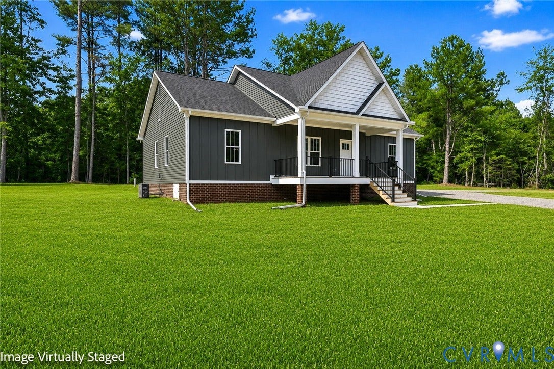 3289 Cumberland Road, Cumberland, VA 23040 Exterior featuring charcoal gray siding, white trim windows, a ground-level wood deck, dark shingle roofing, and a gravel driveway