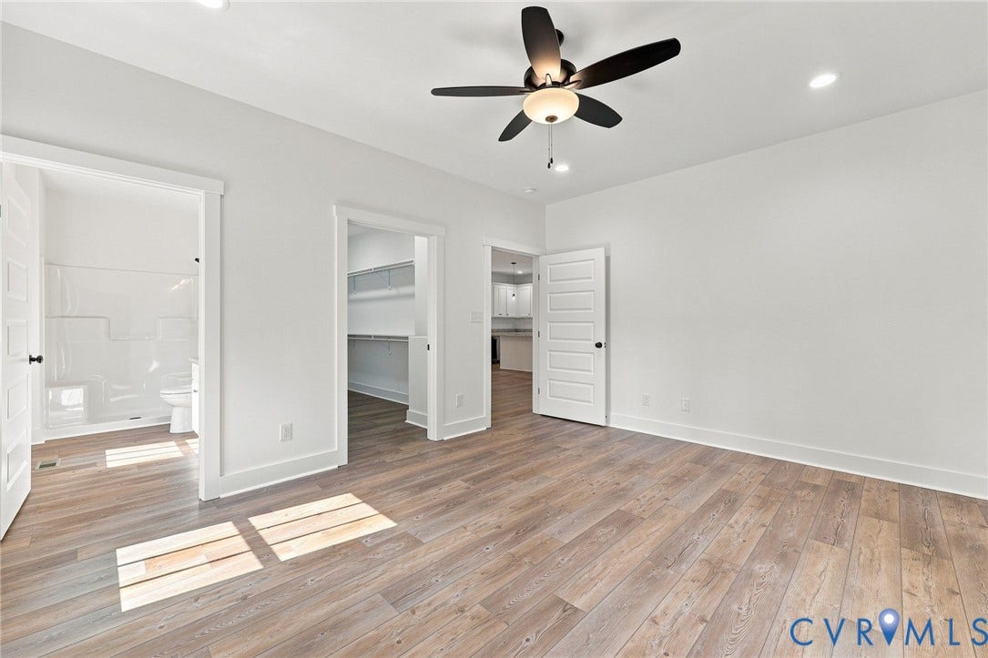 3289 Cumberland Road, Cumberland, VA 23040 White cabinetry, light-toned countertops, stainless steel appliances, wood-finish flooring, and pendant lighting
