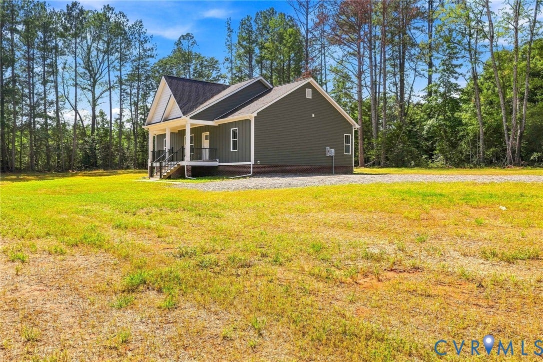 3289 Cumberland Road, Cumberland, VA 23040 Contemporary home with an elevated front porch, dark siding, white trim, and a gravel driveway
