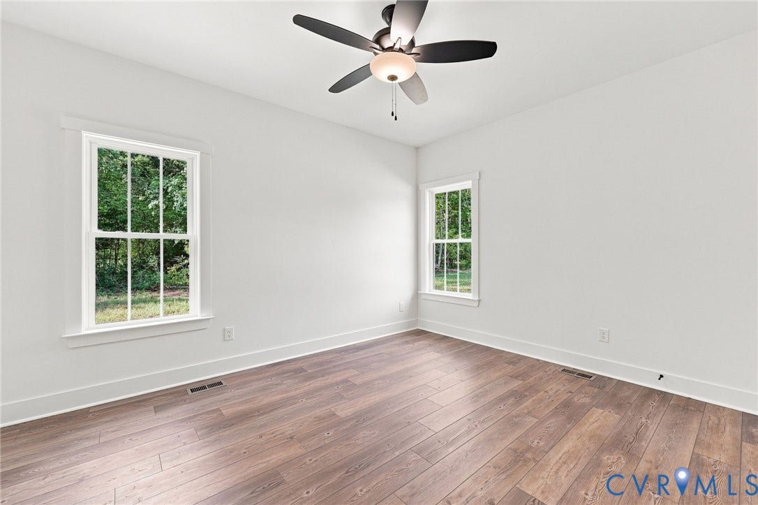 3289 Cumberland Road, Cumberland, VA 23040 Open-concept living area featuring wood-finish flooring, a contemporary ceiling fan, and a kitchen with white cabinetry, stainless steel appliances, and a central island