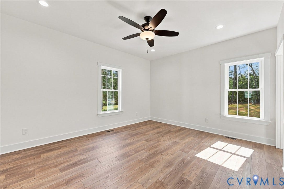 3289 Cumberland Road, Cumberland, VA 23040 Green siding exterior with a dark shingled roof, featuring a wooden deck with railing, white trim windows, and a brick foundation