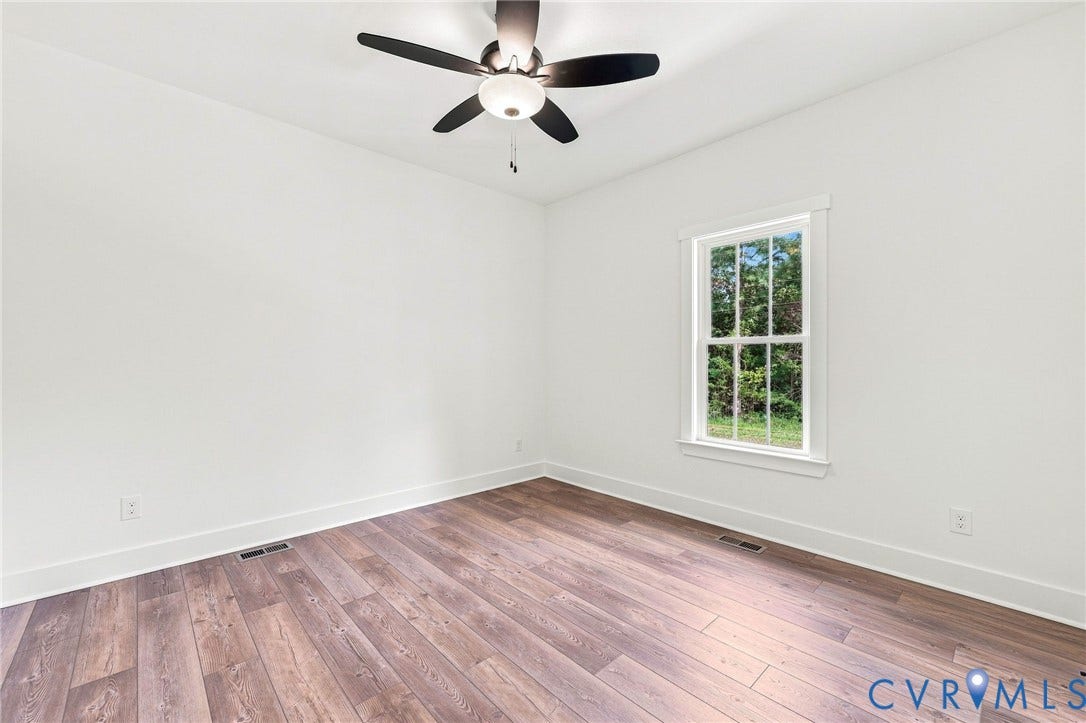 3289 Cumberland Road, Cumberland, VA 23040 Spacious wooden deck with natural wood railings, featuring a verdant tree-lined background and an open grassy area