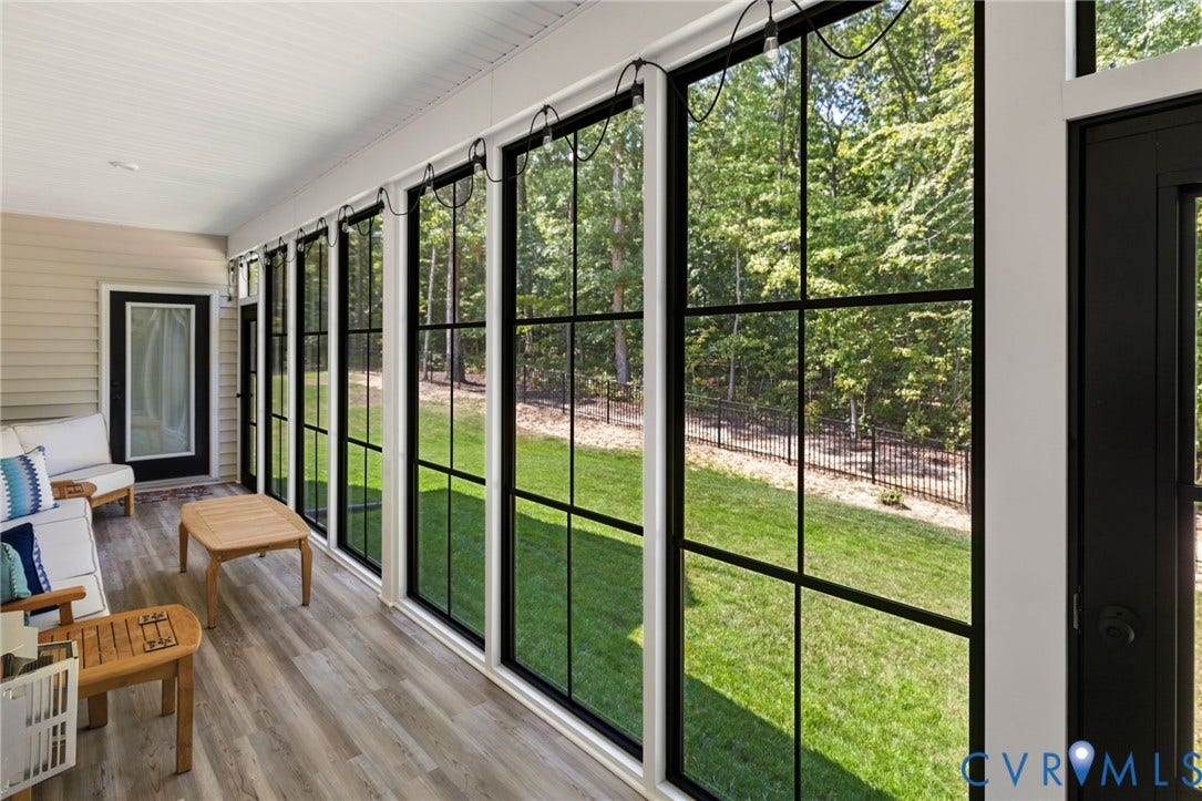 Screened porch with wood-finish flooring, extensive grid-pattern windows, and a beadboard ceiling
