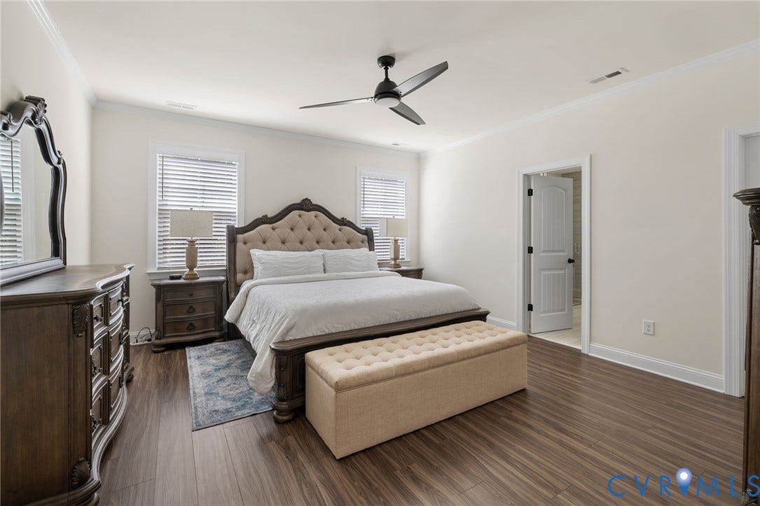 Wood-finish flooring, white walls, and a ceiling fan