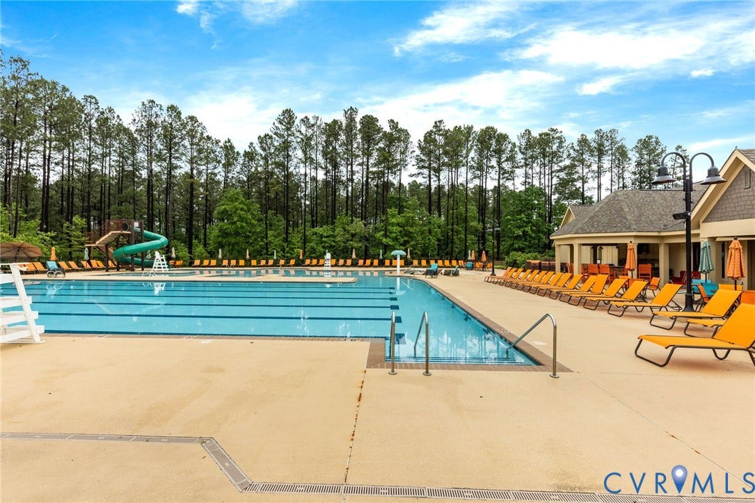 Expansive outdoor swimming pool with integrated water slide and multiple lane markers