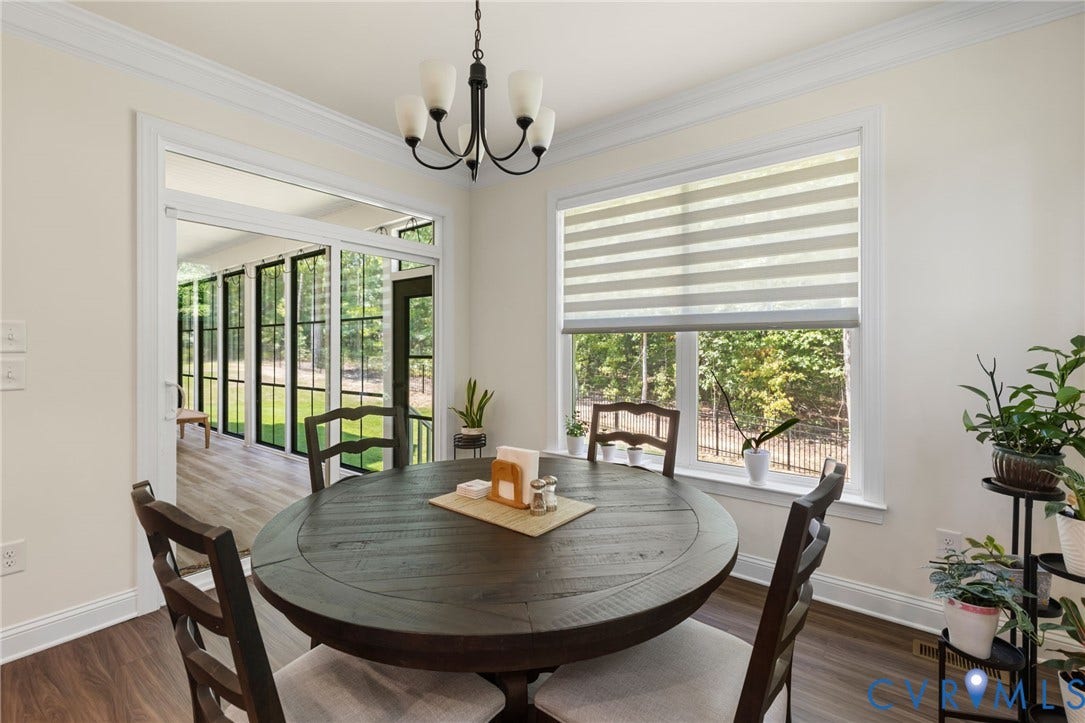 Wood-finish flooring, crown molding, and a contemporary chandelier
