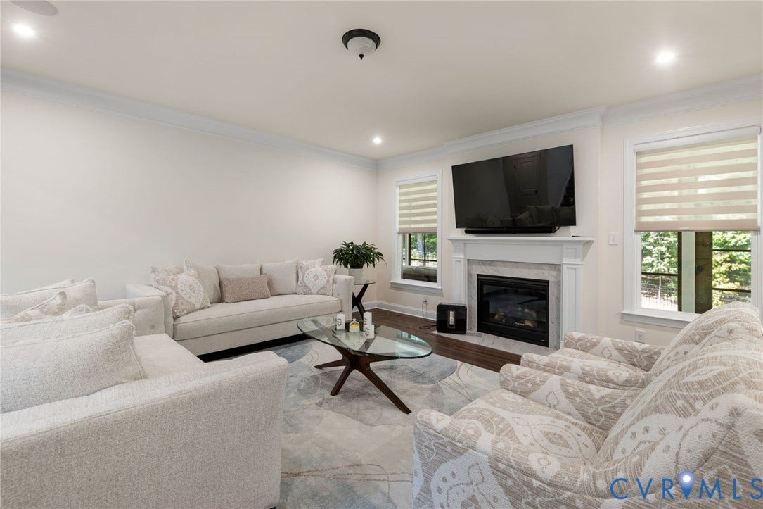 Living space featuring a white mantel fireplace, recessed lighting, crown molding, and wood-finish flooring